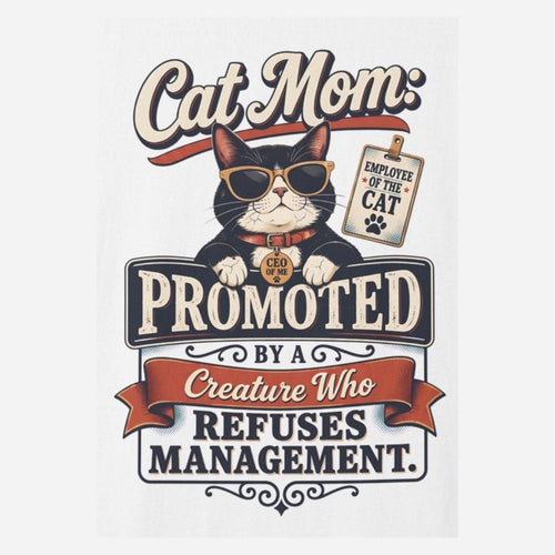 Close-up of the cat mom badge print: a tuxedo cat in gold sunglasses behind a PROMOTED sign with a red ribbon reading BY A CREATURE WHO REFUSES MANAGEMENT, on the White tee